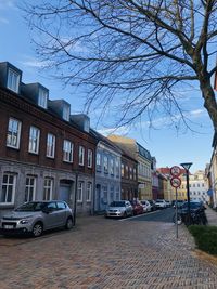 Cars on street by buildings in city