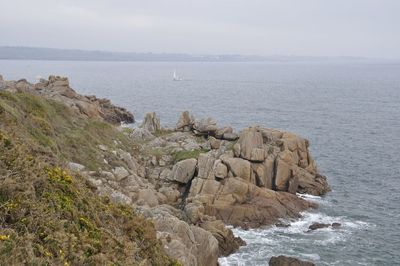 Rocks on sea shore against sky