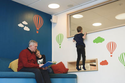 Grandfather with grandsons in library