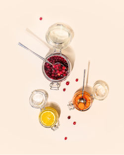 Healthy food composition with glass jars with honey-fermented cranberries, lemon and carrot 