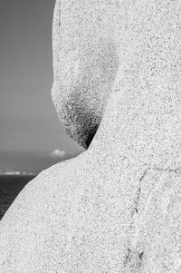 Close-up portrait of young man on rock against sea