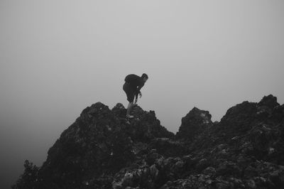 Low angle view of people standing on rock