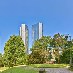 Low angle view of modern buildings against clear blue sky