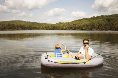 Girl with father sitting in inflatable raft