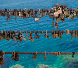 Panoramic shot of padlocks on railing by sea