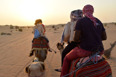 Rear view of couple on sand at beach