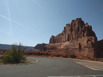 Road leading towards mountain against clear sky