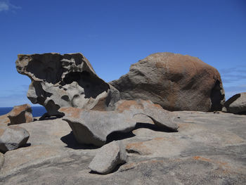 Low angle view of rock formations against clear blue sky