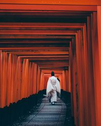 Full length rear view of woman walking on steps against building