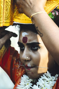 Close-up portrait of woman holding cross