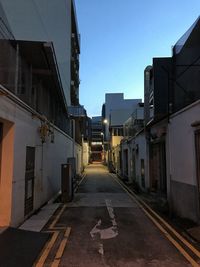 Empty alley amidst buildings against sky in city