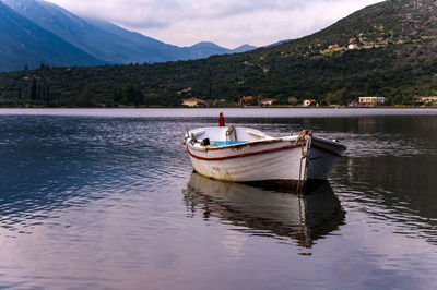 Boat moored in lake against sky