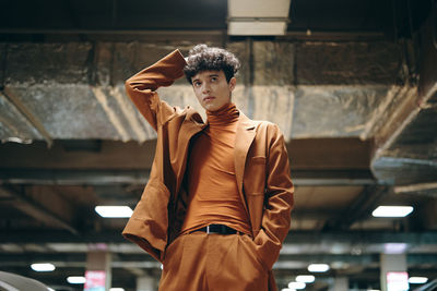 Young woman standing against wall
