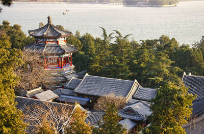 High angle view of traditional building by trees against sky