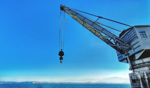Low angle view of cranes against sky