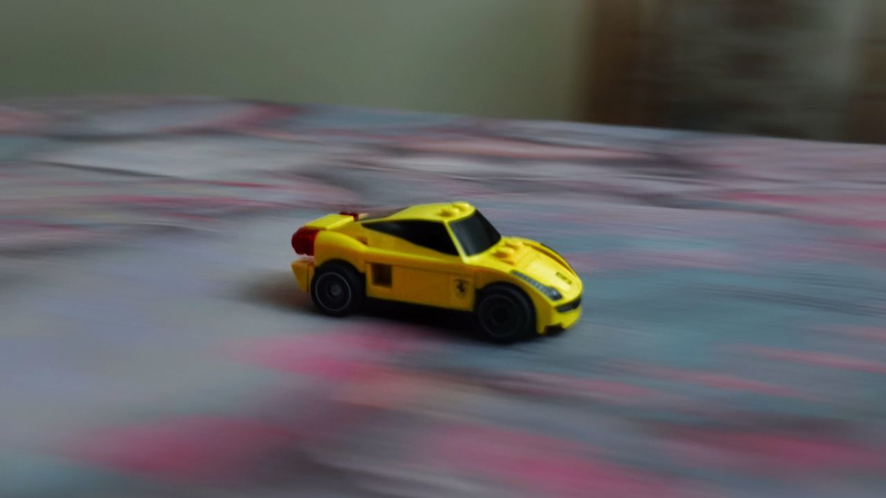 YELLOW TOY CAR IN PARK