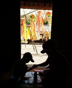 Silhouette people at multi colored glass