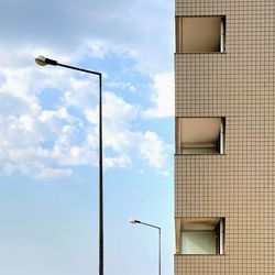 Low angle view of street light against building in city