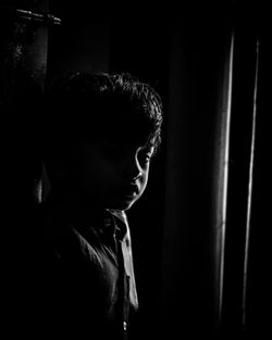 Portrait of boy standing in darkroom