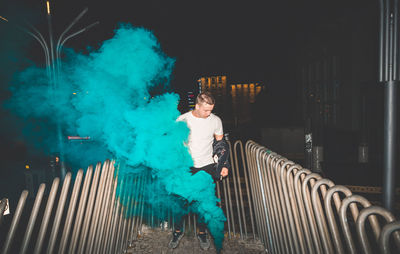 Full length of man on illuminated railing at night