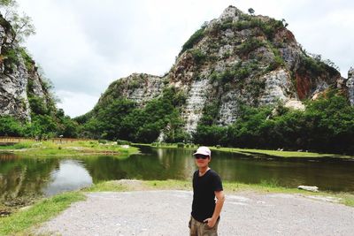 Portrait of man standing by lake against mountain