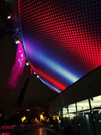 Low angle view of illuminated city against sky at night