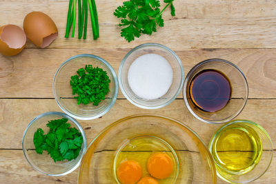Directly above shot of egg yolks surrounded with various ingredients on table