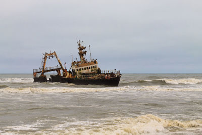 Fishing boat in sea against sky