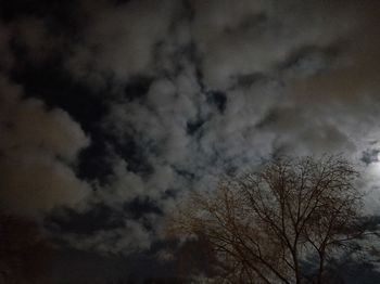 Low angle view of bare tree against cloudy sky