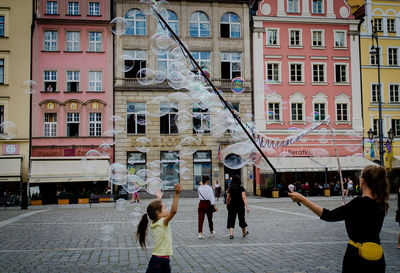 People on street against buildings in city