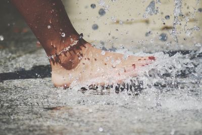 Low section of woman splashing water