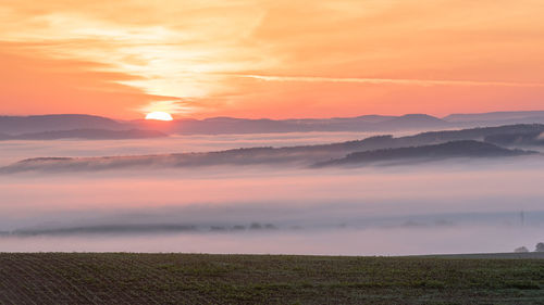 Scenic view of field against sky during sunset