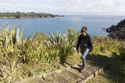 Full length of young woman in sea against sky