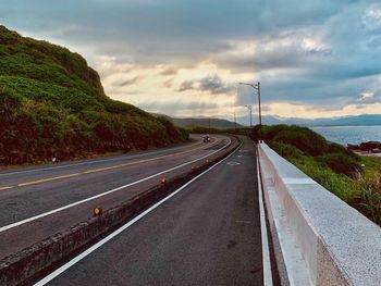 Road leading towards mountain against sky