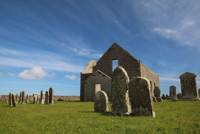 Tombstones in cemetery against sky