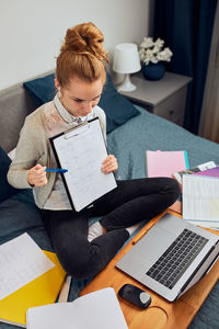 High angle view of woman using phone on table