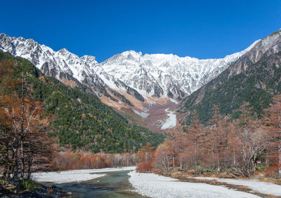 Autumn scenery of the snowy mountains and the river flowing from them.