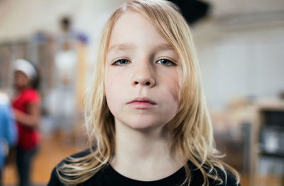 Portrait of girl with blond hair standing at school