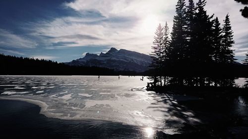 Scenic view of lake by snowcapped mountains against sky