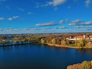 Scenic view of river by buildings against sky