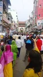 Rear view of people walking on street in city