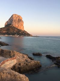 Scenic view of rocks in sea against clear sky