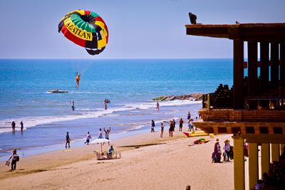 People at beach against clear sky