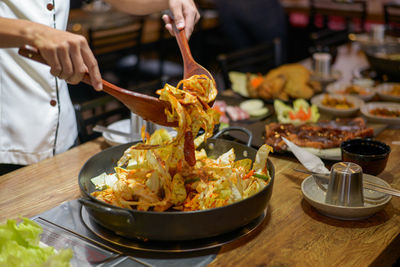 Midsection of person preparing food in restaurant