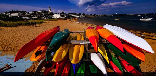 Multi colored boats moored on beach against sky