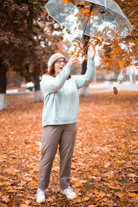 Full length of a man holding autumn leaf