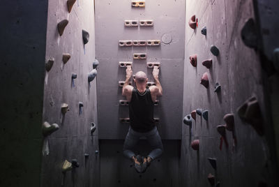 Strong man exercising on a climbing wall doing pull ups