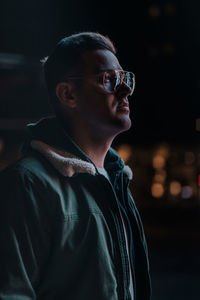 Young man looking away at night