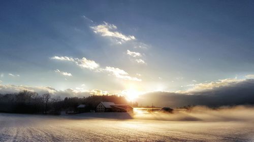 Scenic view of snow covered landscape against sky during sunset