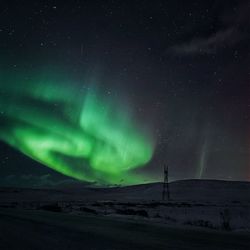 Scenic view of snowcapped landscape against sky at night